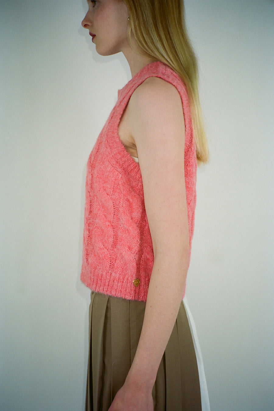 Cable knit sweater vest in candy pink on model