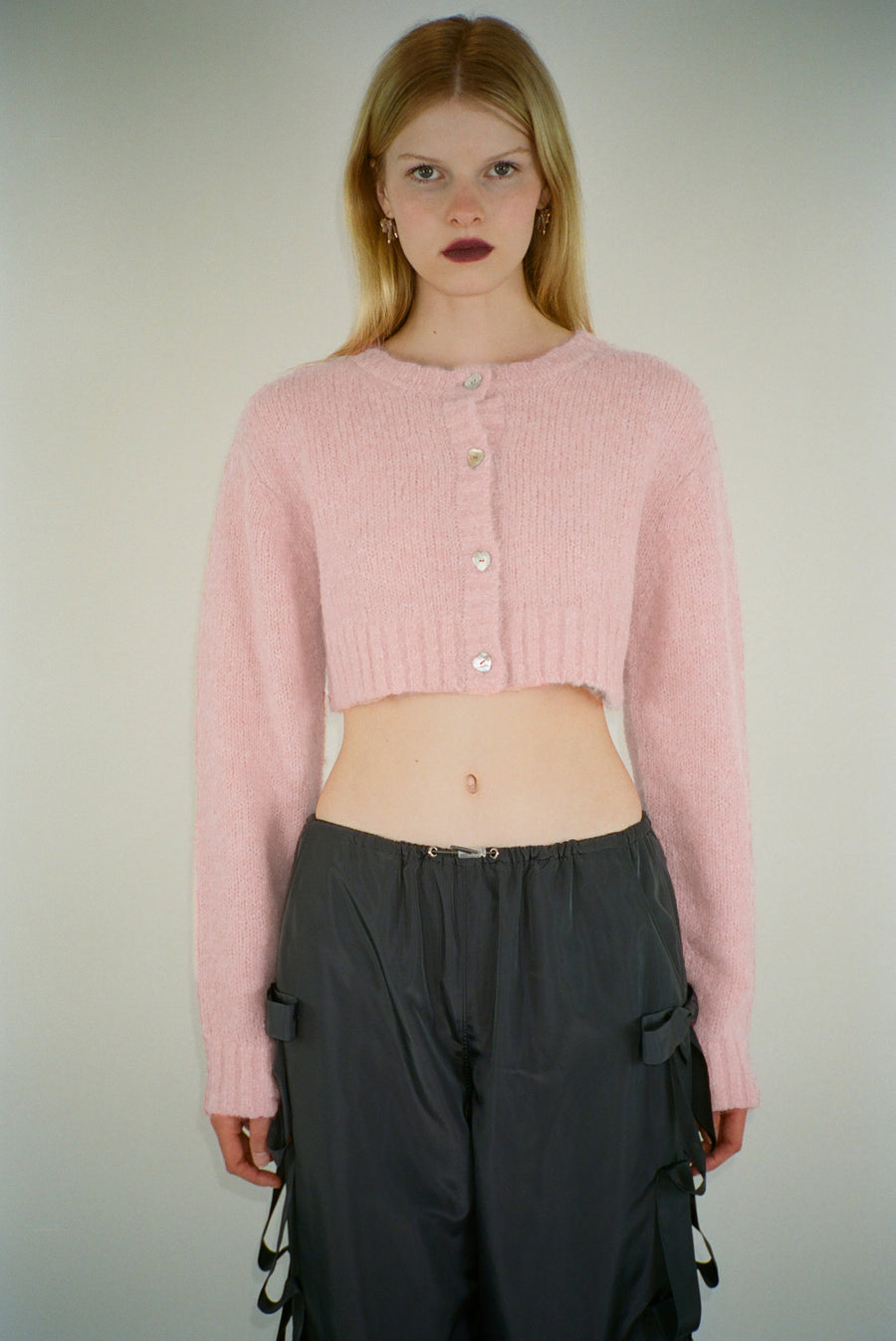 Cropped knit cardigan in blush pink with buttons on model
