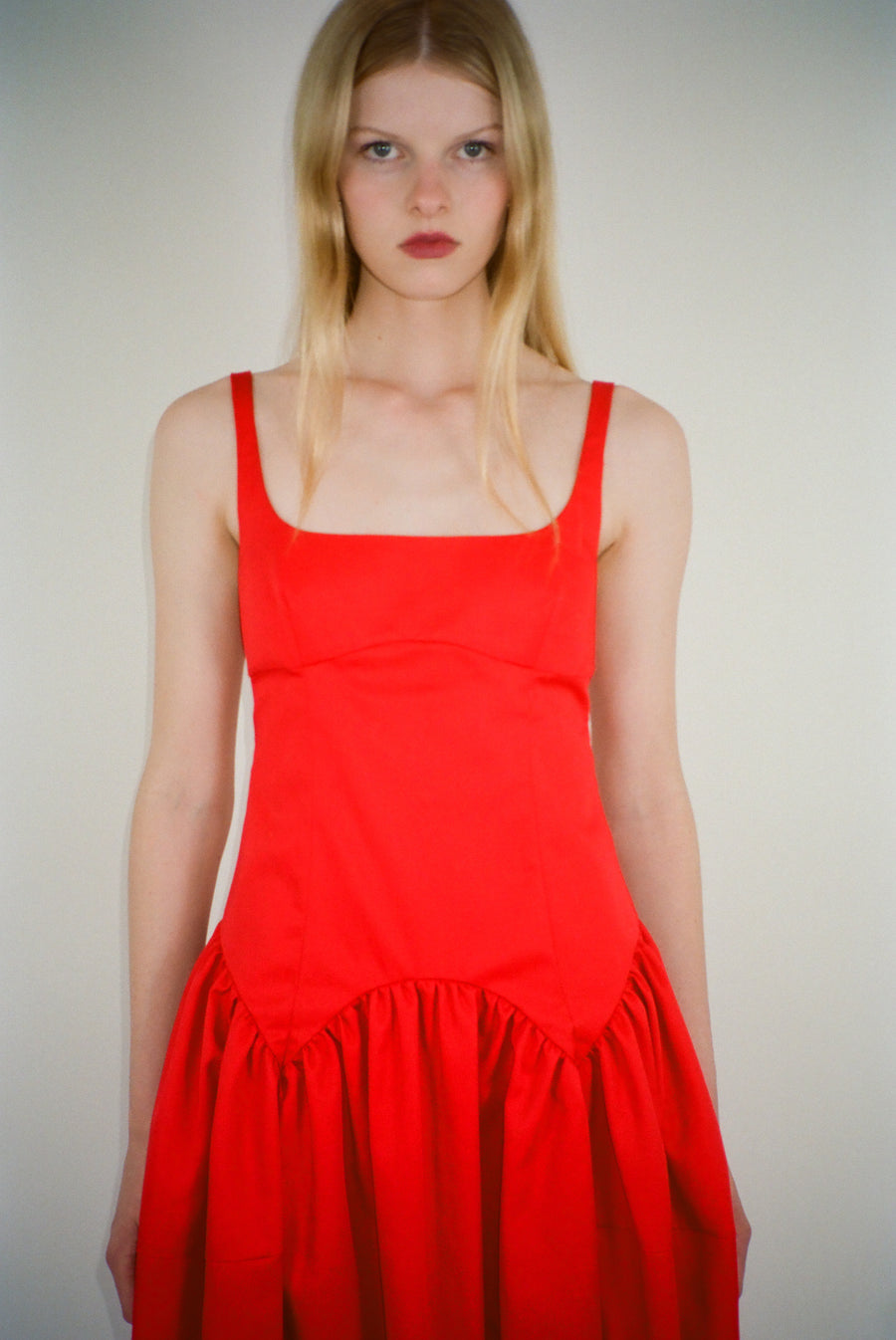 Sleeveless midi length dress in red with ties at back on model