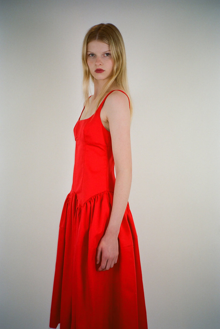 Sleeveless midi length dress in red with ties at back on model