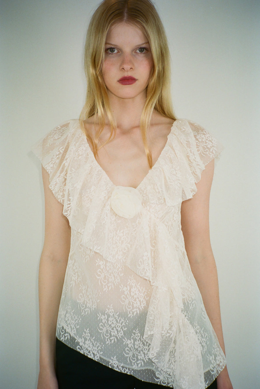 Sleeveless lace top in off white with rosette appliques on model