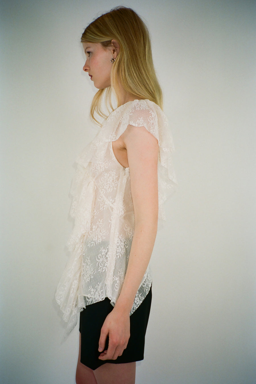 Sleeveless lace top in off white with rosette appliques on model