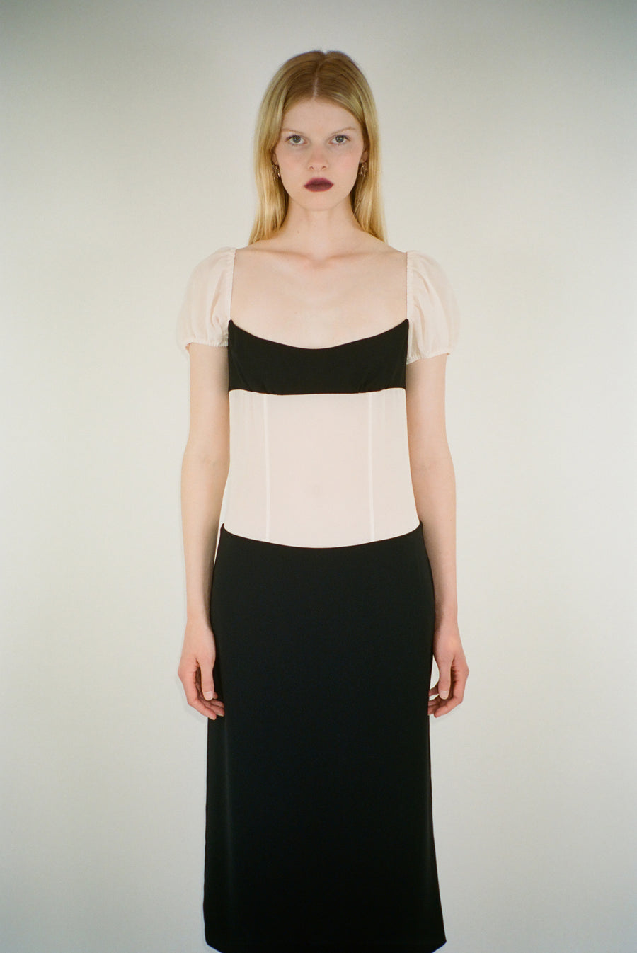 Midi length dress in off white and black with sheer bodice on model