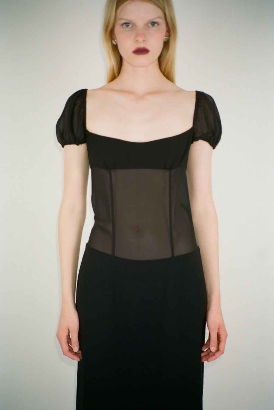 Midi length dress in black with sheer bodice on model
