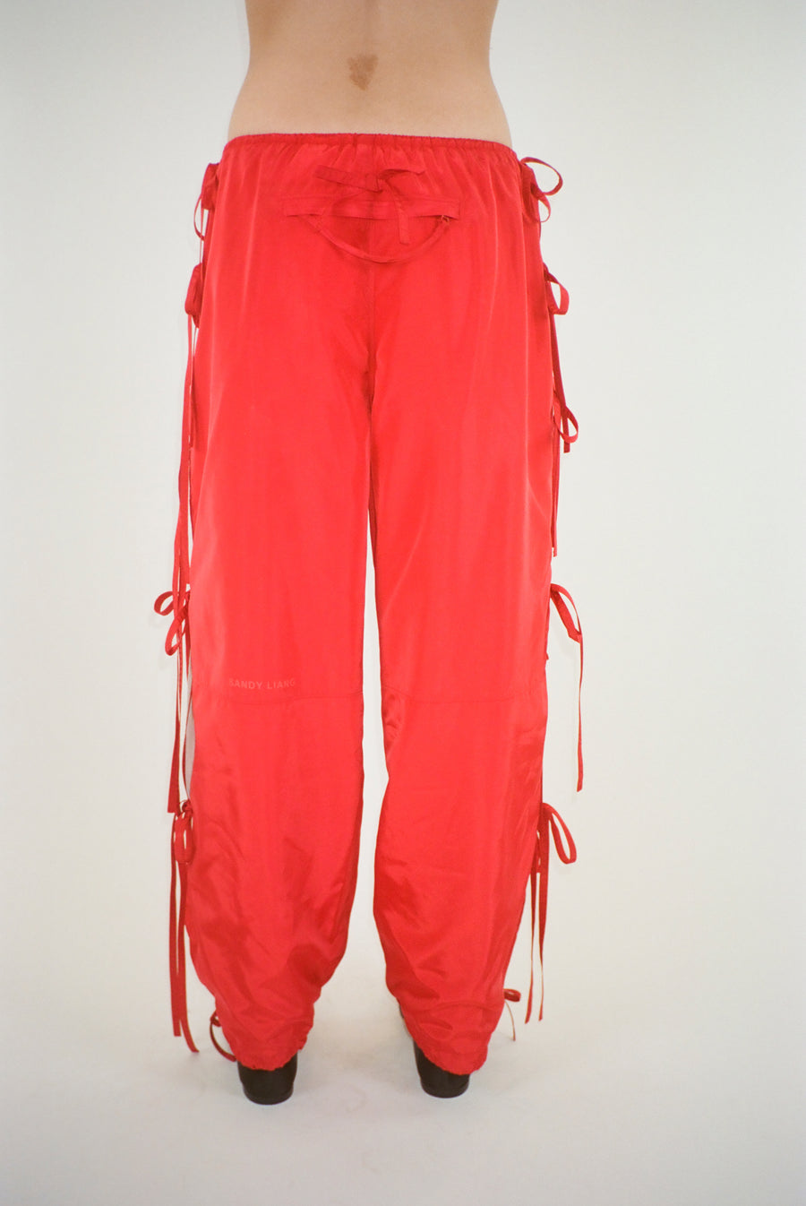 Trackpant in red with slits and ties at sides on model
