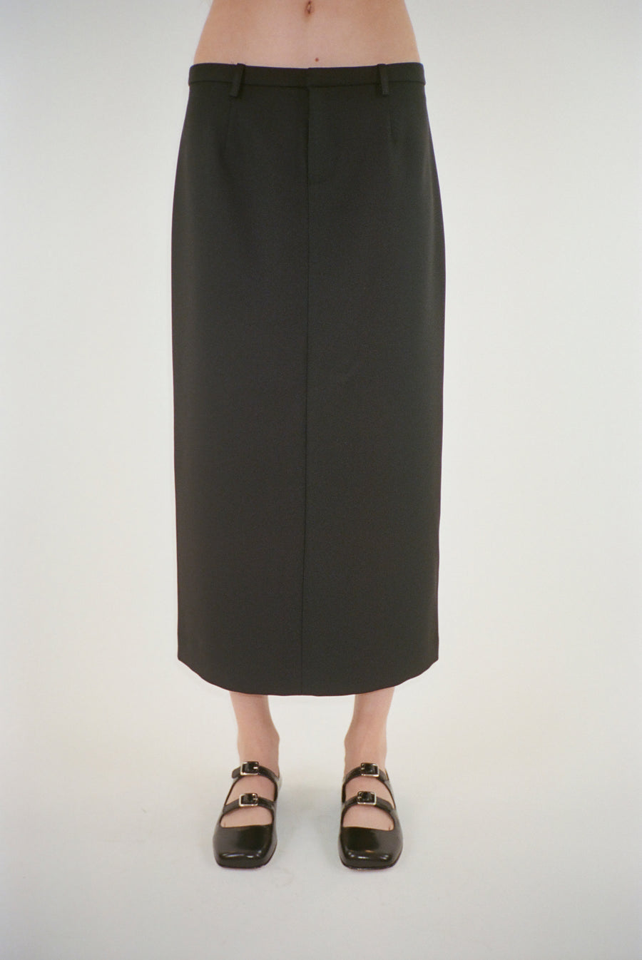 Midi length skirt in black suiting fabric on model
