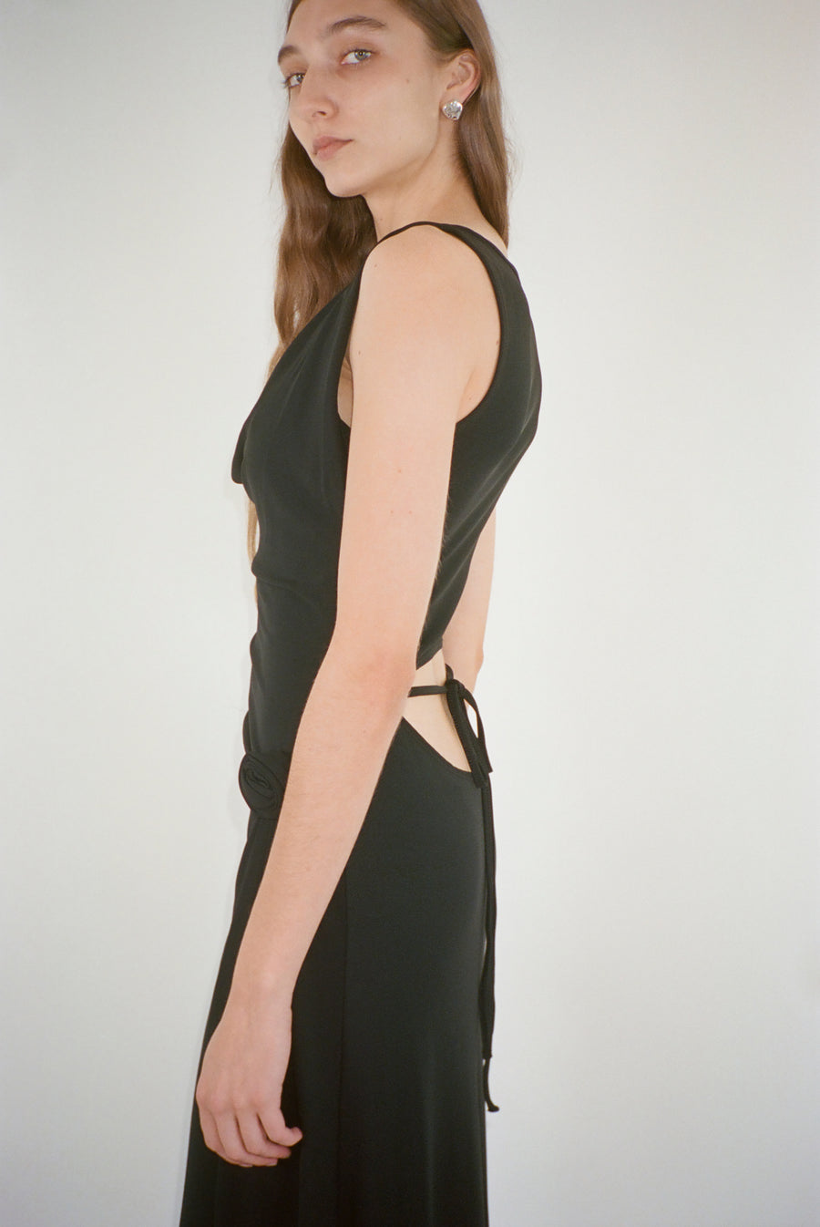 Midi length dress in black with draping and rose detail on model