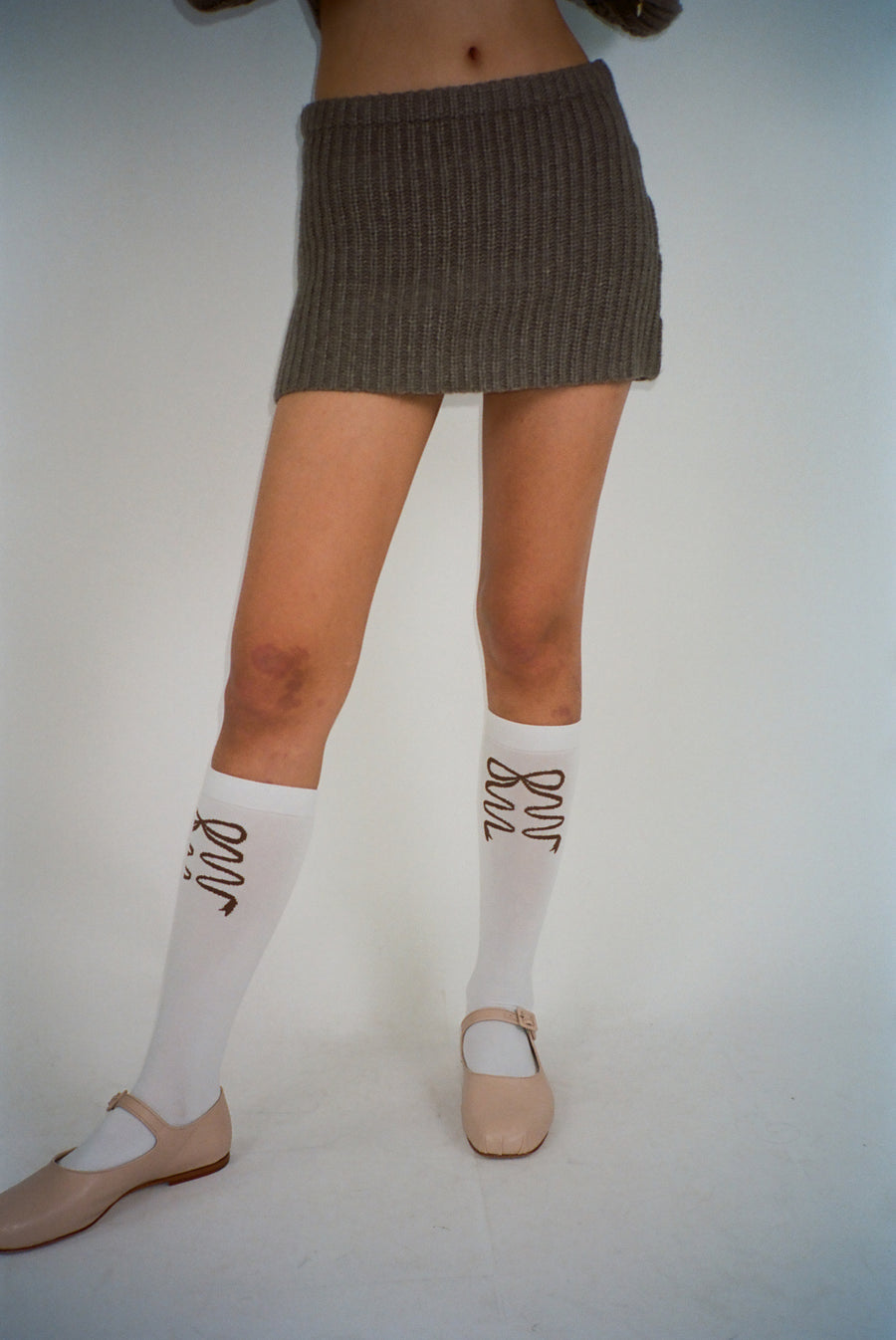 White knee high socks with brown bows on model