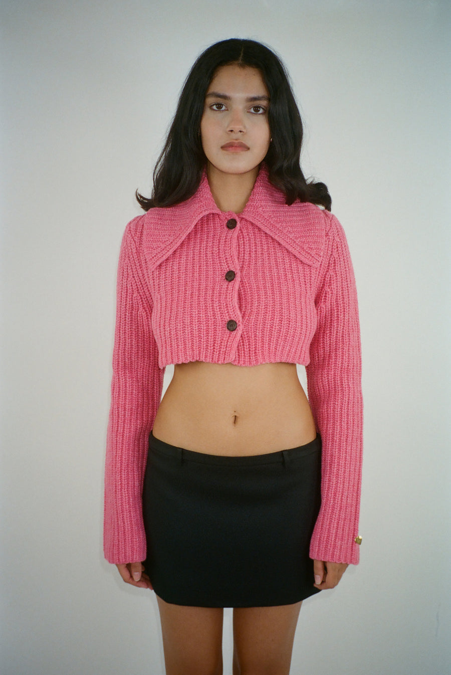 Cropped cardigan sweater in carnation pink with button closure on model
