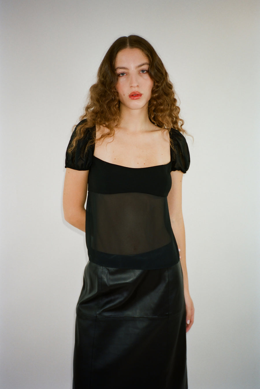 Short sleeved top in black with semi sheer bodice on model