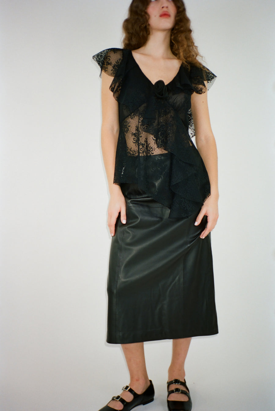 Sleeveless lace top in black with rosette appliques on model