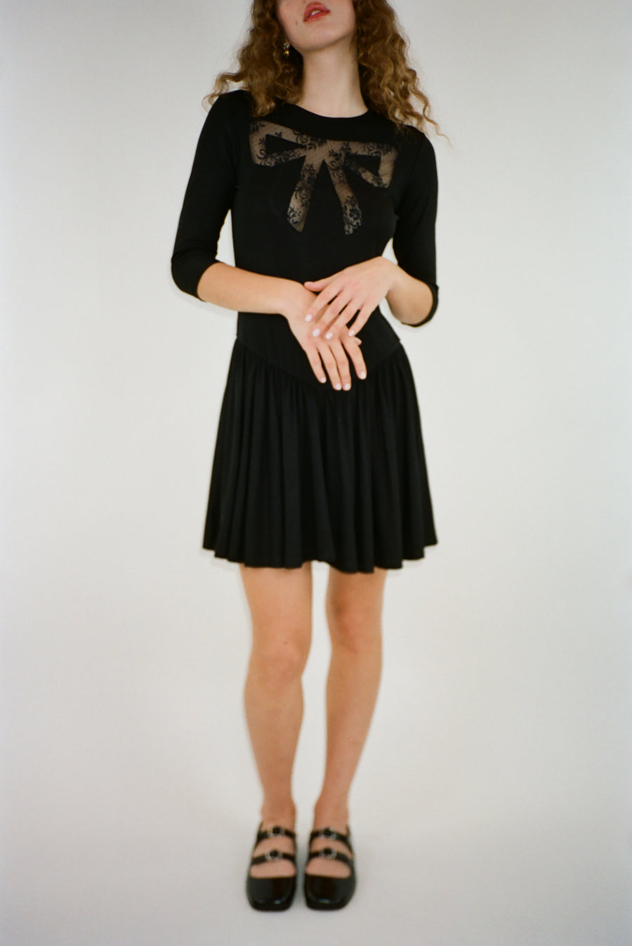 Mini dress in black with lace cut out bow detail on model