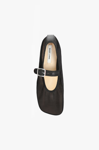A top view of a single black mesh Mary Jane flat with a square toe, padded leather footbed, and an adjustable pin-buckle strap against a white backgorund