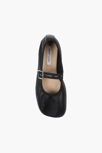 A  top view of a single black Mary Jane shoe with a buckle strap and a low heel on a white background.