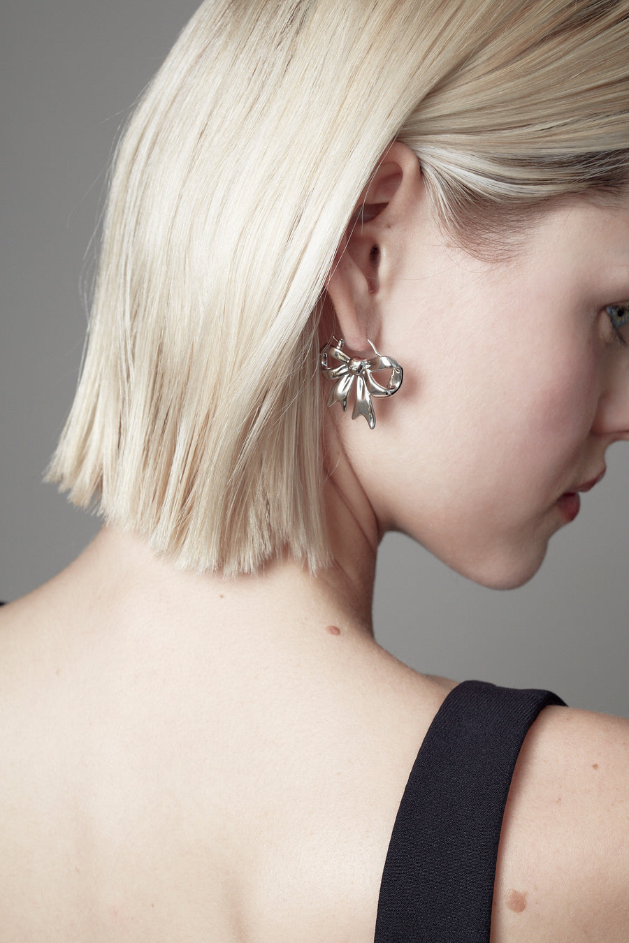 Sterling silver plated bow earrings on model