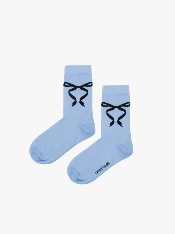 Baby blue crew length socks with black bows on either sides
