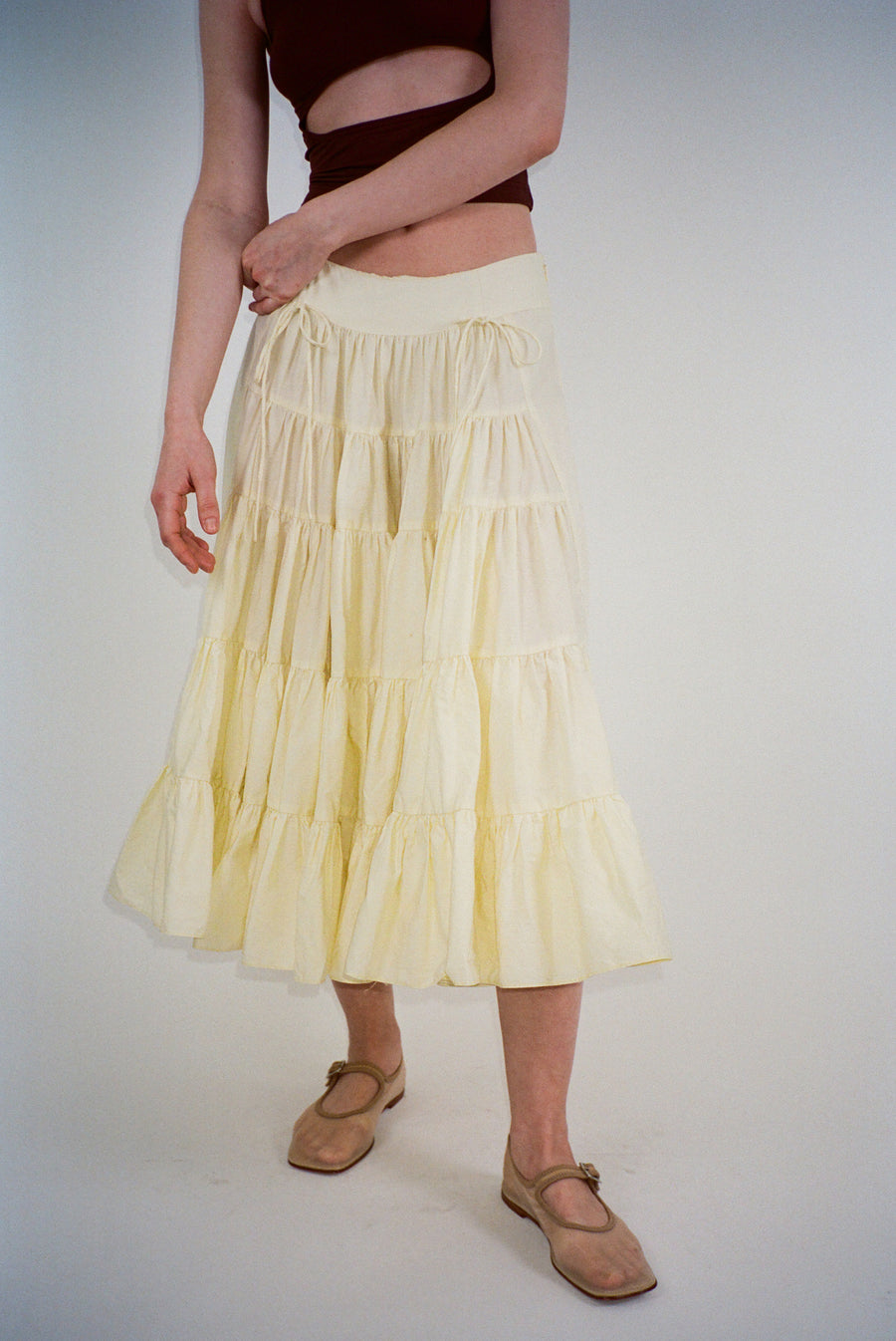 Midi length skirt in yellow with tiered construction on model