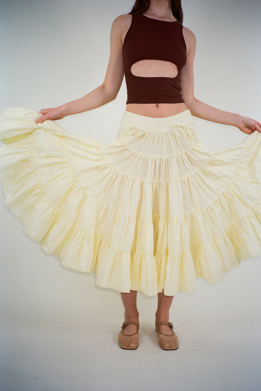 Midi length skirt in yellow with tiered construction on model