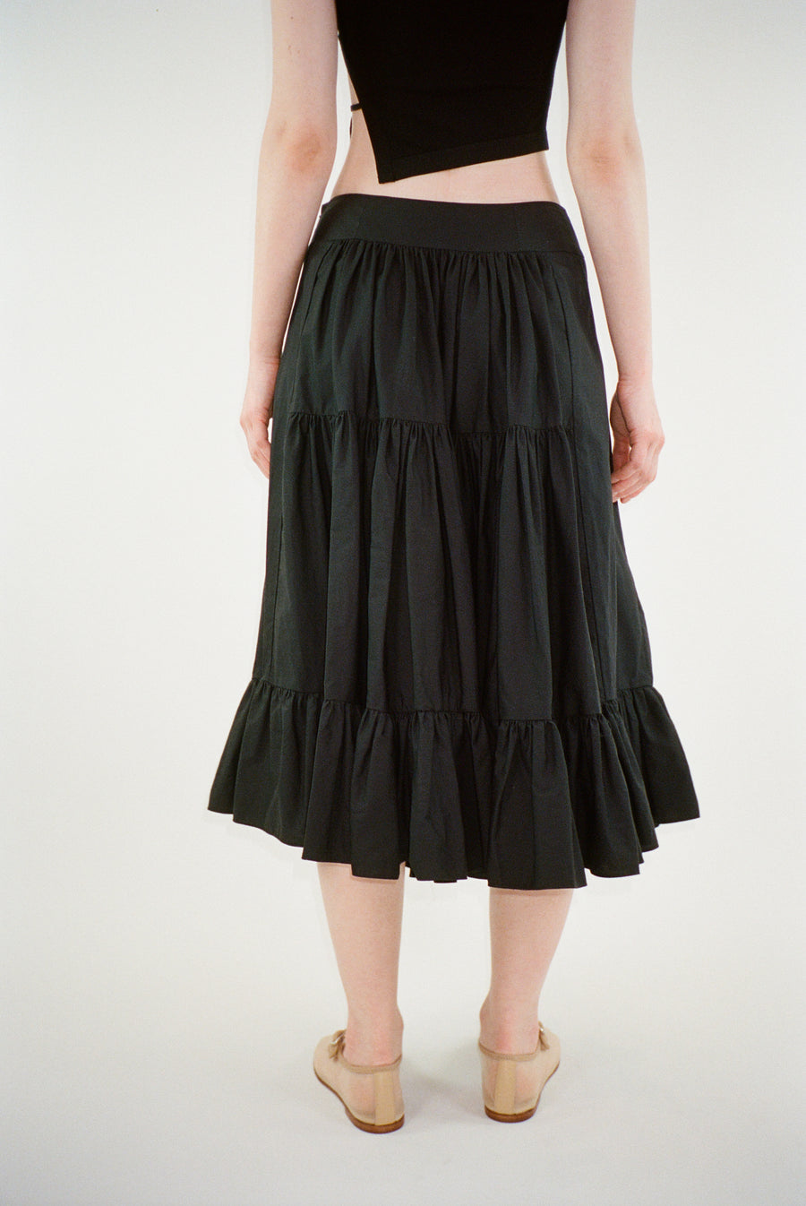 Midi length skirt in black with tiered construction on model