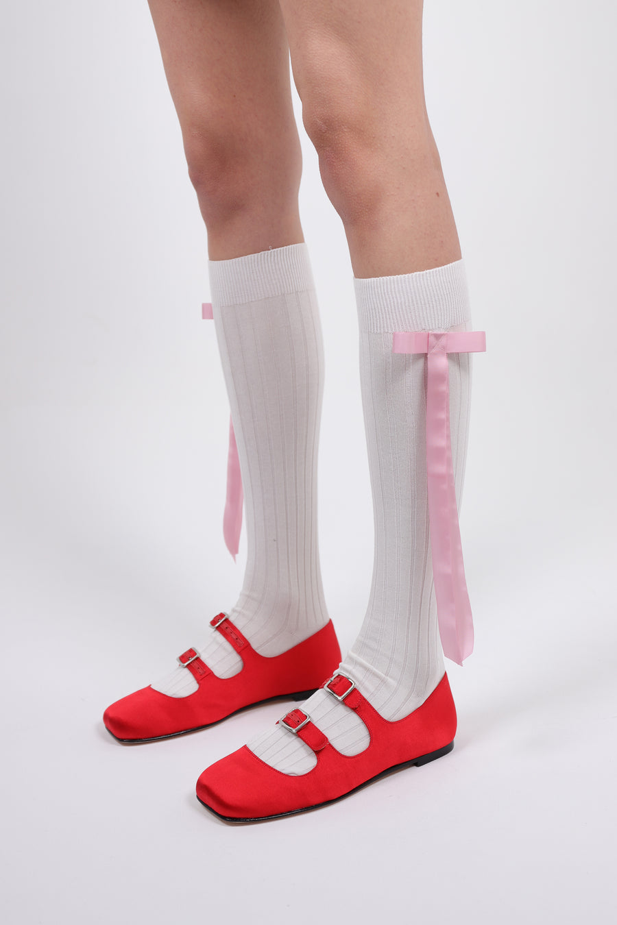 Cotton blend knee high socks in off white with pink long satin bows at side on model