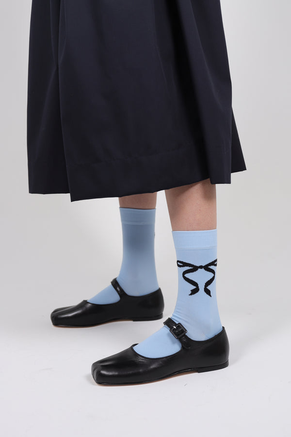 Baby blue crew length socks with black bows on either sides
