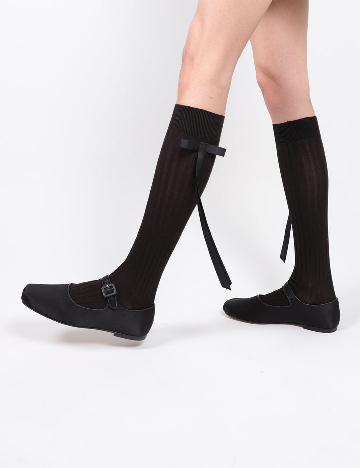 Cotton blend knee high socks in black with black long satin bows at side on model
