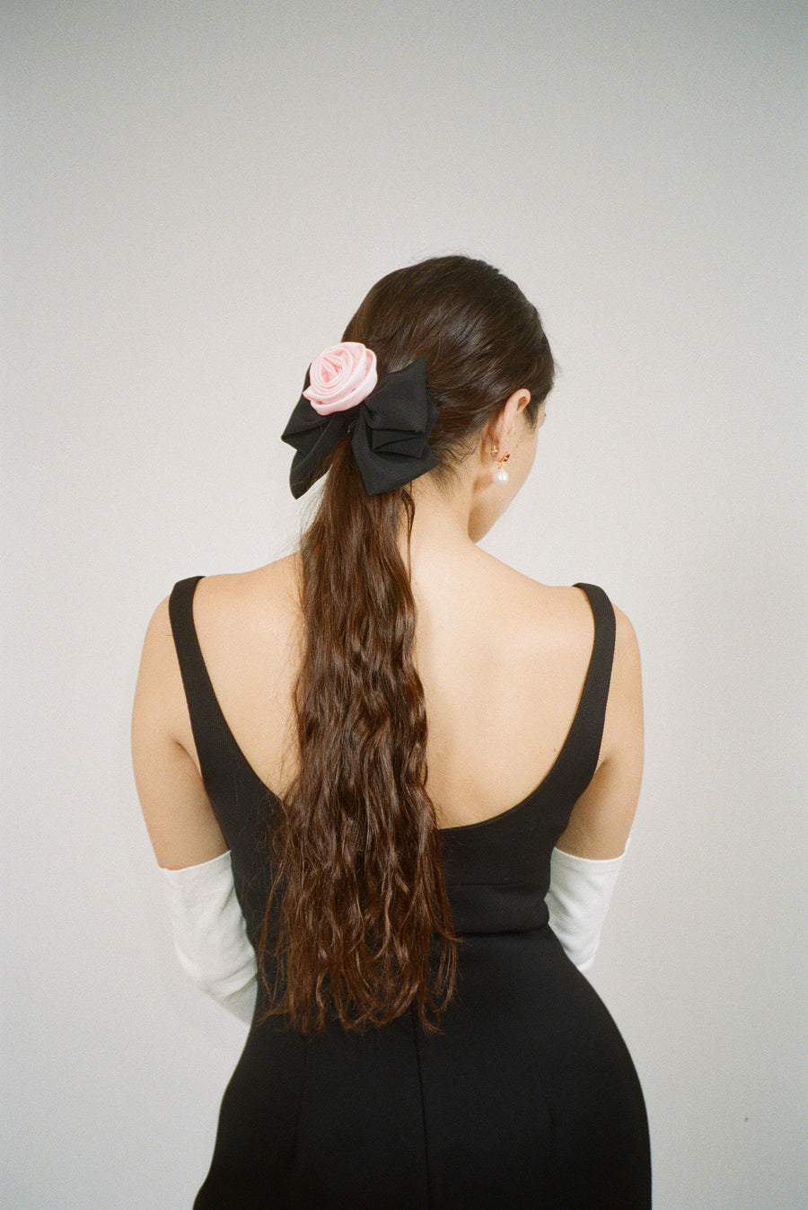 Black hair bow with pink satin rose on model