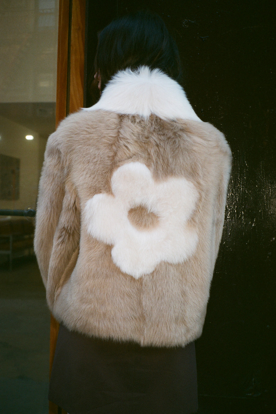Light brown shearling jacket with flower detail at back on model