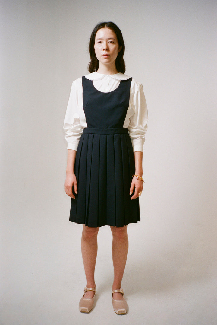 Wool pleated mini dress in navy on model