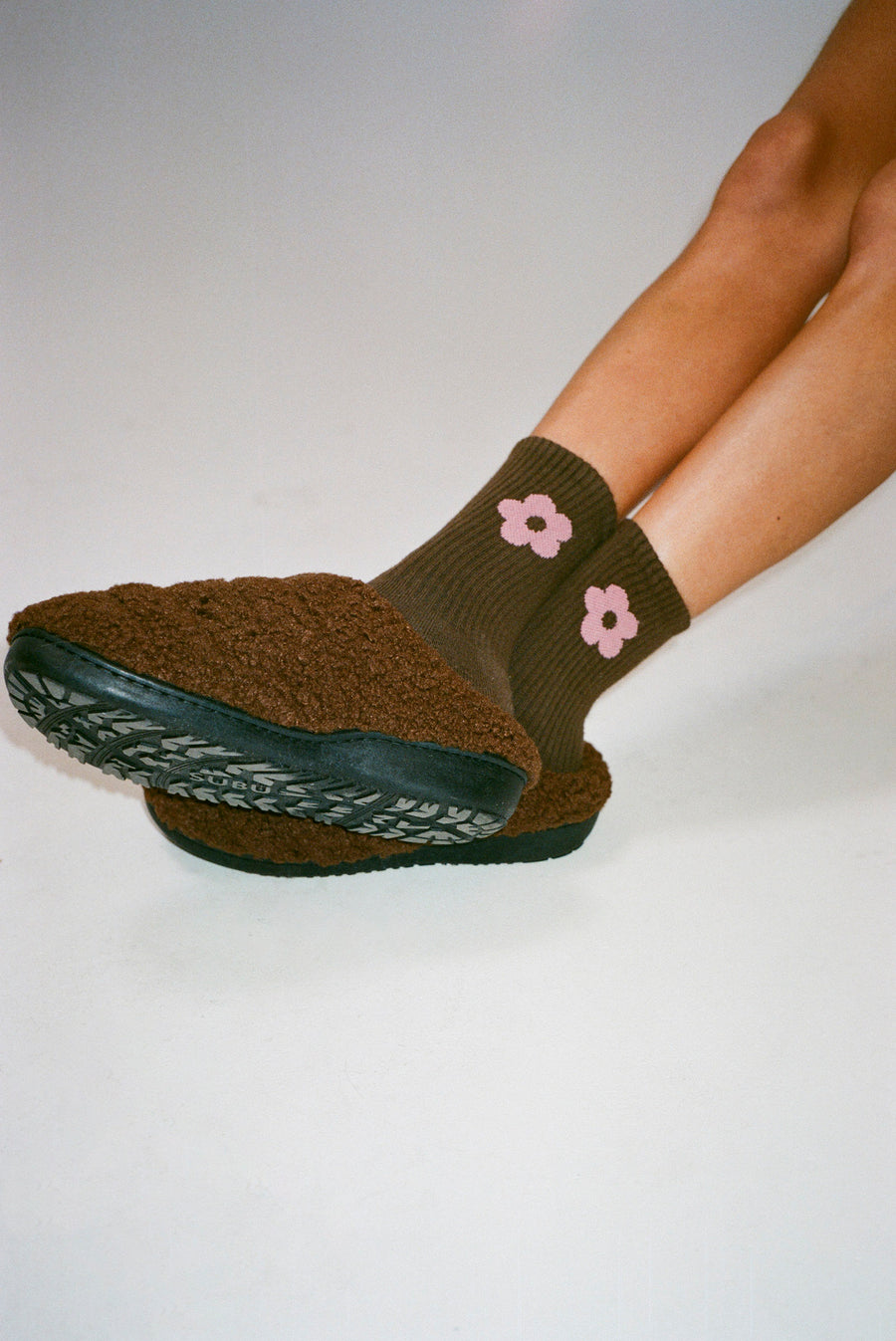 Brown crew length sock with pink flower on either side on model